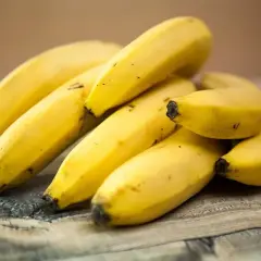Kupka żółtych bananów na drewnianym blacie. Czy banany są zdrowe? Tak, to pyszna i pożywna przekąska!