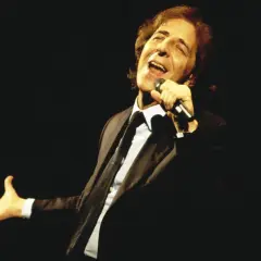 Giorgio Gaber canta con passione, la sua voce risuona come nei testi de "Il Conformista", un'icona della musica italiana.