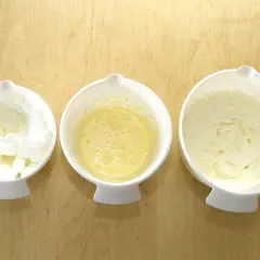 Tre skålar med bakningsingredienser: vispad äggvita, äggsmet och fluffigt smör och socker som vispats poröst.