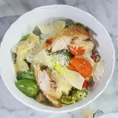 En härlig caesarsallad med kyckling, parmesan och krutonger, generöst täckt med krämig caesarsallad dressing.