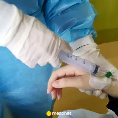 Rękawiczki medyczne przygotowują zastrzyk tocilizumabu.