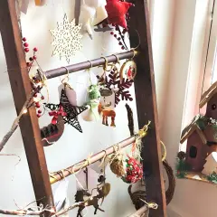 Eine Leiter weihnachtlich dekorieren: Sterne, Schneeflocken, Rentiere und Lichterketten schmücken die Sprossen.