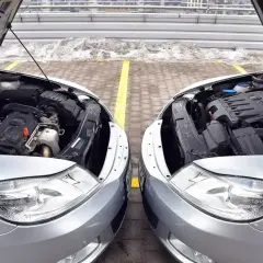 Dwa silniki samochodowe, jeden diesel, drugi benzyna, z otwartymi maskami.