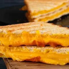 Dos sándwiches de queso a la parrilla, con queso derretido y dorado, el mejor queso para sandwich.