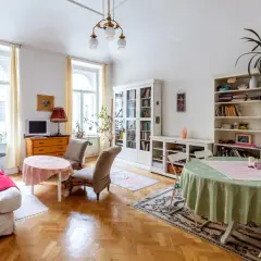 Przytulny salon z kanapą, dwoma fotelami, regałami i stołami. Idealne miejsce na umowa na czas nieoznaczony.