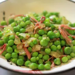 Guisantes con jamón, un plato sencillo y delicioso. Los guisantes frescos se mezclan con trocitos de jamón y cebolla salteada, creando un sabor casero irresistible.