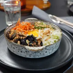 En vacker skål med bibimbap, fylld med ris, grönsaker, svamp och ett stekt ägg. Perfekt för ett snabbt och gott bibimbap recept.
