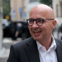 Uśmiechnięty łysy mężczyzna w okularach i garniturze. Robert Kropiwnicki wykształcenie zdobył, by budować przyszłość.