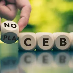 Palec odwraca kostkę z napisem "NO" na "PLACEBO", pokazując, czym jest efekt nocebo.