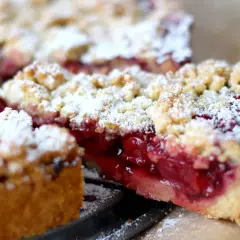 Ein saftiger Kirschkuchen mit knuspriger Streuseldecke, bestäubt mit Puderzucker. Ein Genuss für jeden Kaffeetisch.