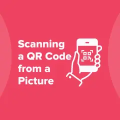 Jak użyć kodu QR ze zdjęcia? Ilustracja pokazuje dłoń trzymającą smartfon z ikoną kodu QR.