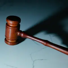 Drewniany młotek sędziowski na marmurowym blacie. Zastanawiasz się, ile trwa apelacja od wyroku cywilnego?
