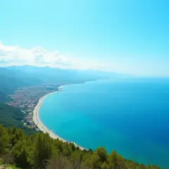 Widok na wybrzeże Turcji, gdzie turkusowe morze obmywa piaszczystą plażę i zielone wzgórza.