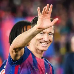 Robert Lewandowski wita kibiców, uśmiechając się szeroko. Wszyscy zastanawiają się, o co chodzi z Lewandowskim i jego nowym klubem.