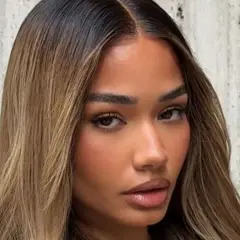Mujer con cabello castaño oscuro con mechas rubias, un estilo que inspira cómo aclarar el pelo para un look radiante.
