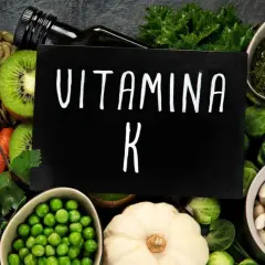 Variedad de alimentos ricos en vitamina K2: zanahorias, kiwi, semillas de calabaza, guisantes, coles de Bruselas, judías blancas y hierbas.