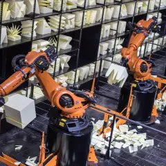 Roboterarme im Museum der Industriekultur formen weiße Objekte.
