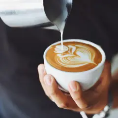 Barista tworzy latte art na kawie. Czy cappuccino ma kofeinę? Tak, zawiera ją espresso.