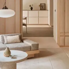 Gemütliches Wohnzimmer im Japandi Stil mit Sofa, Couchtisch und Holzelementen.