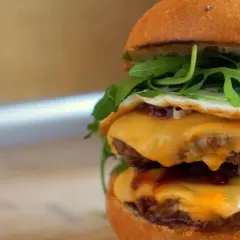 Pyszny McMuffin farmerski przepis: podwójny kotlet, ser, jajko sadzone, rukola i sos. Idealny na śniadanie!