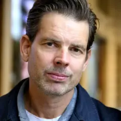 Alex Schulman, en svensk författare och programledare, poserar framför Dramaten.