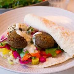 Falafel i pitabröd med färgglada grönsaker och en krämig sås. Ett perfekt falafel recept för en snabb och god lunch.