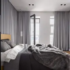 Nowoczesne rodzaje zasłon w sypialni, tworzące przytulną atmosferę. Szare tkaniny okrywają okna i drzwi balkonowe, dodając elegancji.
