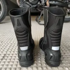 Botas de moto negras, un elemento que es obligatorio llevar en la moto para proteger tus pies.