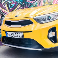 Żółty, stonic kia z pirackim graffiti w tle.