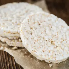 Stos lekkich wafli ryżowych na papierze, idealnych na niskokaloryczną przekąskę. Wafle ryżowe kcal to świetny wybór.