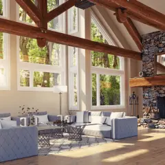 Vaste salon avec cheminée en pierre et un impressionnant plafond cathédrale bois. De grandes fenêtres donnent sur une forêt luxuriante.
