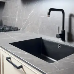 Piano cucina in quarzo effetto marmo con lavello nero e rubinetto moderno. Perfetto per forare top cucina per lavello.