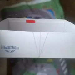 Białe pudełko z logo "NelliBlu" i zaznaczonymi liniami, gotowe do stworzenia własnego **organizer diy**.