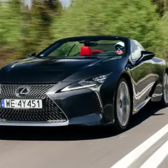 Czarny kabriolet Lexus LC 500 z czerwonym wnętrzem sunie po krętej drodze, zapewniając czystą przyjemność z jazdy i poczucie lexus relax.