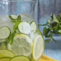 Dzbanek orzeźwiającej, sassy water z cytryną, limonką, ogórkiem i miętą, pełen lodu.