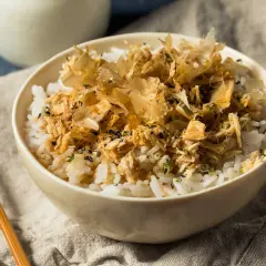Un tazón de arroz blanco con atún desmenuzado y hojuelas de bonito seco.
