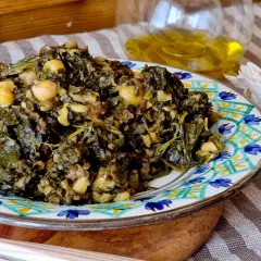 Un plato de garbanzos con espinacas, cocinado con ajo y aceite de oliva.