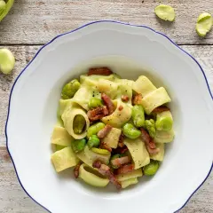 Piatto di pasta con fave fresche e croccante pancetta, un classico saporito.