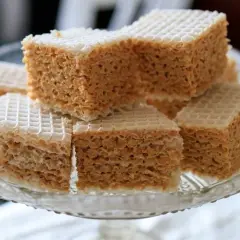 Słodkie wafle z mlekiem w proszku, ułożone na szklanej paterze. Chrupiące warstwy przełożone kremowym nadzieniem.