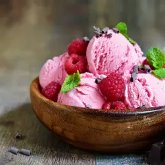 Himbeereis selber machen ohne Eismaschine: Cremiges Eis mit frischen Himbeeren und Minze in Holzschale.