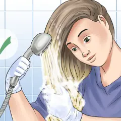 Mujer con guantes se aclara el pelo teñido con una ducha. Un visto bueno indica éxito.
