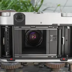 The open back of a Fuji GF670W medium format camera, revealing the film path and lens.