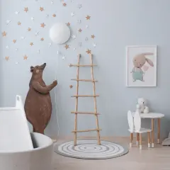 Douce couleur peinture chambre bébé bleu ciel, décorée d'étoiles et d'un ours. Un coin jeu avec toboggan et tapis.