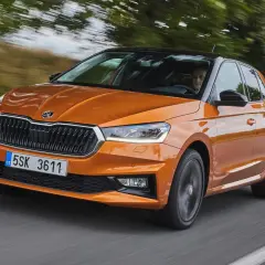En orange Skoda Fabia kör på en väg. Inga problem med denna bil, bara en härlig tur.