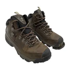 Well-worn brown hiking boots, one with the sole coming off, showing signs of many adventures.