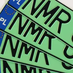 Kilka zielonych tablic rejestracyjnych z literami "NMR" i symbolem Unii Europejskiej.