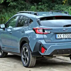Szary Subaru Crosstrek 2025 na tle zieleni i wody. Gotowy na przygodę!