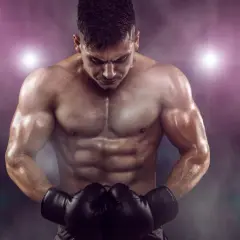 A muscular boxer shows off his powerful boxing body, sweat glistening under the arena lights.