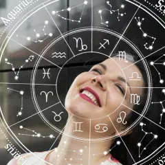 Uśmiechnięta kobieta na tle koła zodiaku. Sprawdź swój horoskop na jutro, zwłaszcza jeśli jesteś Lwem!