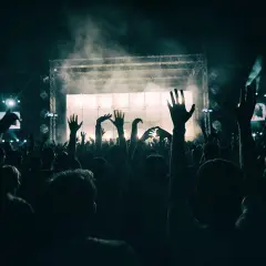 Folla in estasi al ritmo del dj techno berlino, mani alzate verso il palco illuminato.